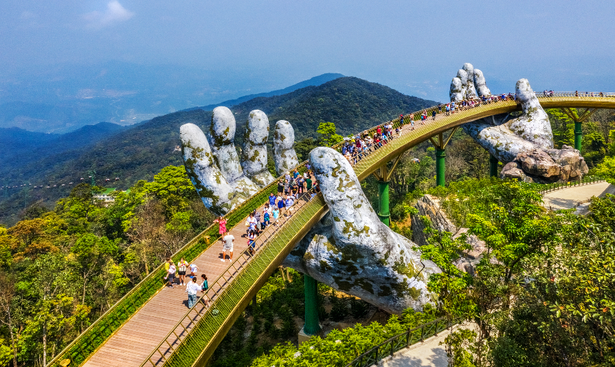Aerial view of the Golden Bridge is lifted by two giant hands in the tourist resort on Ba Na Hill in Da Nang, Vietnam