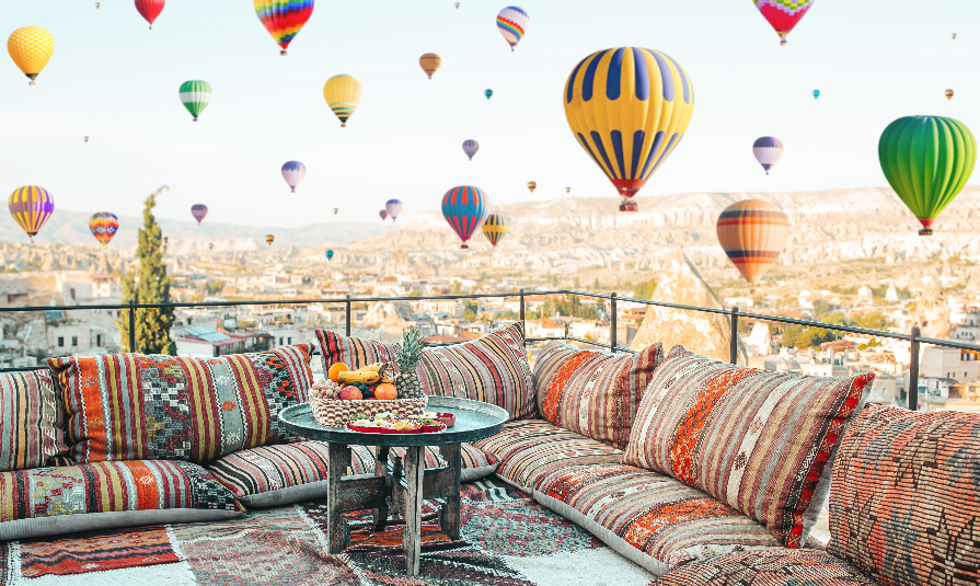 View of the city of Goreme with caves and air baloons in Cappadocia.