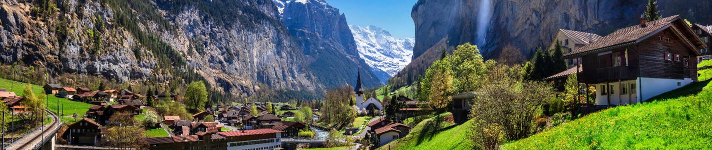 Switzerland nature and travel. Alpine scenery. Scenic traditional mountain village lauterbrunnen with waterfall  surrounded by snow peaks of Alps. Popular tourist destination and ski resort